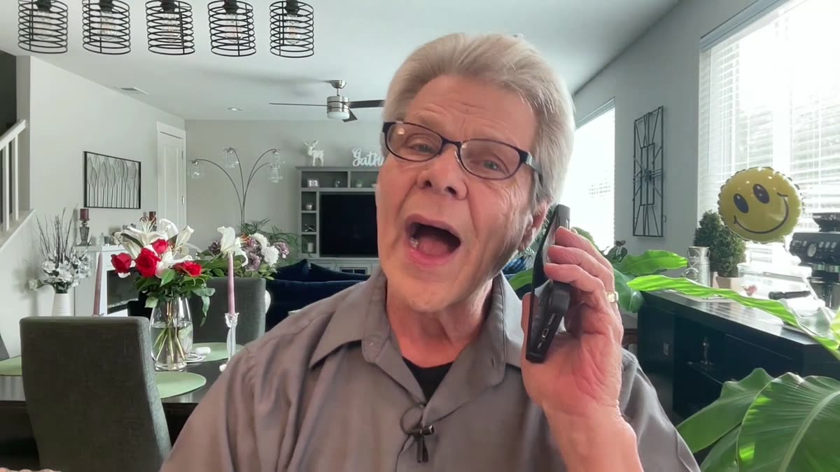 Rob Fore holding a phone to his ear, mid-sentence, playing a scam caller in his video
